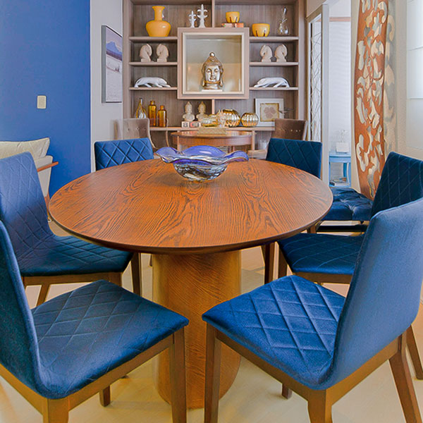 Jogo de jantar com mesa oval e cadeiras estofadas azuis.